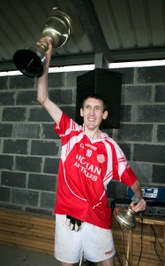 Éire Óg captain John Griffin lifts the cup after victory over Cooraclare. Photograph Arthur Ellis.