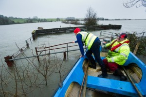 Gerry Murtagh and his son Damien  float by their submerged cattle crush yard with flood damage on over 20 acres of their farm at Lacknashannagh, Kildysart on the Shannon Estuary. Photograph by John Kelly.