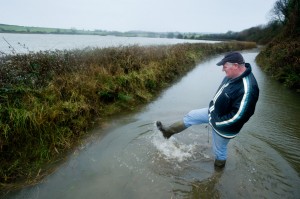 Local farmer Tom Finn at the entrance to his farm at Lacknashannagh, Kildysart on the Shannon Estuary, where he has 22 acres of grazing and meadow under severe flood. Photograph by John Kelly.