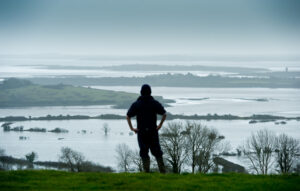 Young Paul O Sullivan of Cooga, Kildysart looking out over the family farm and other neighbour's farms which are under deep flood water from the Shannon Estuary. Photograph by John Kelly.