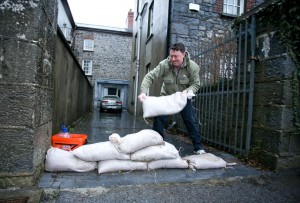 Garrett Ahern lays sandbags at the entrance to his home in Thomond Villas, Clarecastle over the weeekend. Photograph by Arthur Ellis