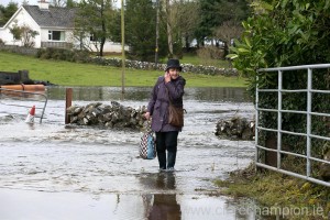 Mary Collins makes her way home from shopping through flood water in Skehanagh near Ardrahan in South Galway. Photograph by Arthur Ellis.