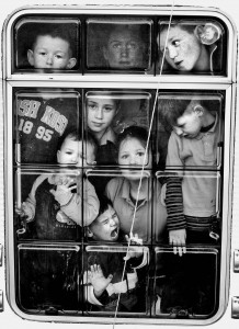 Caroline Sherlock and her seven children at the window of a caravan, which they share on the side of the road at Cregg, Lahinch, Co Clare.