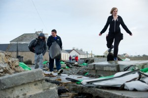 Locals negotiates their way through the trail of destruction on the main road in Kilbaha village which is cut off to traffic following the latest high seas and gales. Photograph by John Kelly.