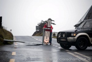 A motorist clears a fallen direction sign from a road in West Clare