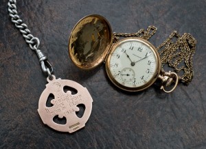 A view of the inscription on the back of a 1914 Clare All-Ireland hurling medal won by Michael Flanagan of Durra House, Barefield along with his pocket watch from the same era. Photograph by John Kelly.