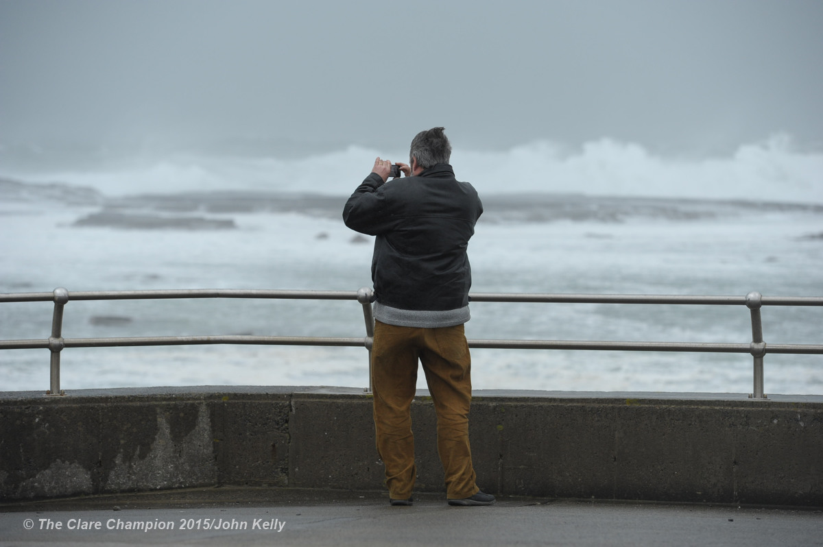 A man photographs the high seas and huge waves forming at The Pollack Holes, Kilkee as the wind picks up on Monday afternoon. Photograph by John Kelly.